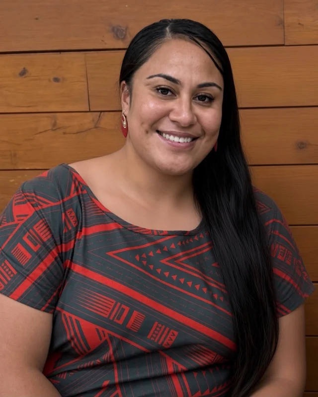 Sia Ropati, smiling, in a red and charcoal Pacific-patterned top.